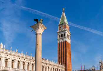 Fototapeta na wymiar Venice, Italy. View of Column of San Marco with lion and St Mark's Campanile on the background of blue sky.