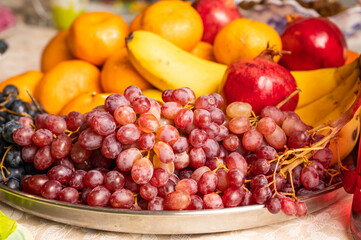 Fruit plate with grapes, pomegranates, tangerines and bananas