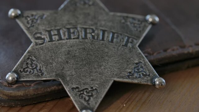 Old west Sheriff badge macro close up on a leather wallet - police in the old west of America