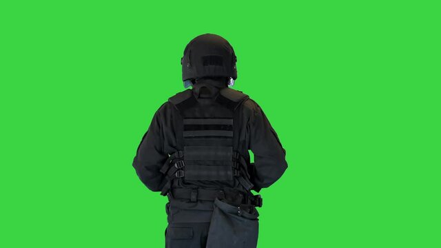 Riot policeman in a helmet jogging on a Green Screen, Chroma Key.