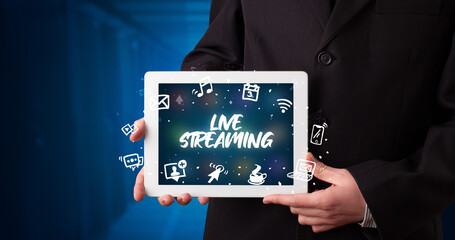 Young business person working on tablet and shows the inscription: LIVE STREAMING