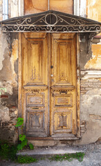 Vintage weathered wooden door under forged visor