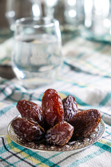 A Heap of Dates Fruit on Traditional Silver Plate. Iftar Appetizer for Muslim People. Usually Eating on  Ramadan. Preparing for Iftar Time. Table Ready for Dinner.