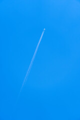  Airliner with vapour trail against a blue sky.