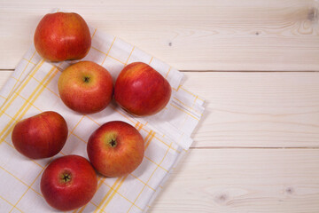 Red apples on napkin on wooden background