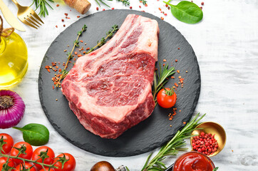 Grilled beef ribeye steak on the bone on a white wooden background. Flat lay. Top view.