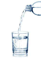 Water pouring from bottle into the glass, isolated on white