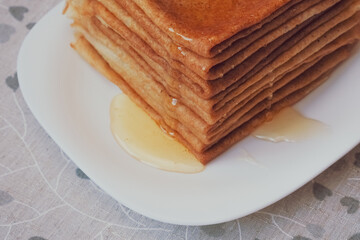 Russian pancakes with honey, closeup. Maslenitsa and crepe week concept
