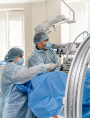 Medics are performing surgical operation in bright modern surgery room. Operating theater. Modern...