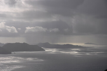 Ocean view over Praslin island with dramatic and overcast sky with sunbeam on the sea