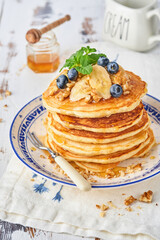 Pancakes with banana, walnut, honey and caramel for a breakfast. Selective focus.