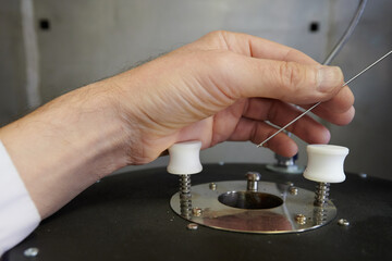 a laboratory assistant with a syringe sends a minimum amount of gasoline to check its chemical composition, physical properties, the presence of impurities and additives