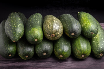 pile of zucchini on a dark wooden table	