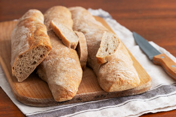 Baguette and baguette slices on a wooden table.