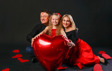 The family keeps the word LOVE Valentine, happiness, on the floor hearts romance. February 14, the honeymoon. love forever, gift in red dress girl, barefoot