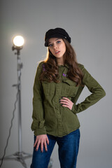 cute blue-eyed girl in a cap poses in the studio