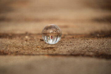 Crystal ball with reflection of trees and a girl in the park