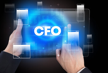 Close-up of a hand holding tablet with CFO abbreviation, modern technology concept