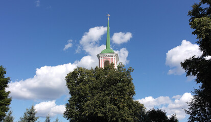 The spire of the Orthodox church and the tree growing in front of it.