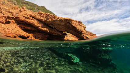 Underwater split photo from rocky sea cave formation in calm sea beach of Avlaki, Porto Rafti,...