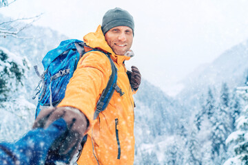 Happy smiling Man dressed bright orange softshell jacket with backpack hand in hand girlfriend...