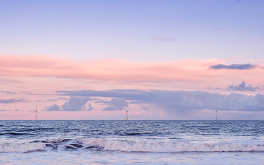 A cold winter afternoon walk at the beach. Win turbines (windmills) with cloudy sky in the background. Pastel colors horizontal image.
Blyth Beach, Northumberland, UK.