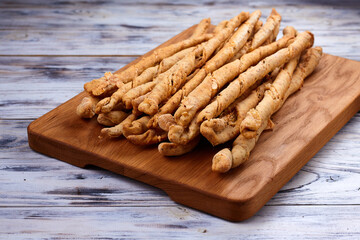 Delicious breadsticks grissini on the wooden table. Italian appetizers.