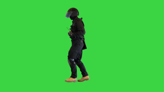 Riot policeman in a helmet jogging on a Green Screen, Chroma Key.