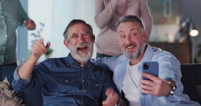 Joyful family of four spending time indoors recording selfie video taking pictures having exciting leisure acrivities home entertainment on weekend.