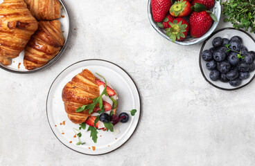 Croissant sandwich with cheese , arugula and berries.