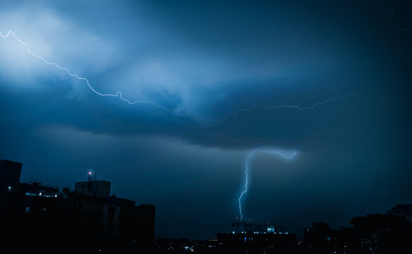 Blue Dramatic tones of Weather . Lightning storm over city. Stormy skyline. Copy space for text. Digitally modified image.
