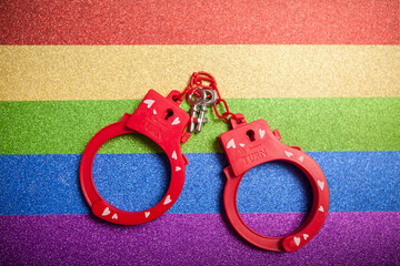 Sex toy handcuffs on rainbow lgbtq+ background