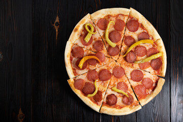 Tasty pepperoni pizza on wood background. Top view of hot pepperoni pizza. With copy space. Flat lay. Banner