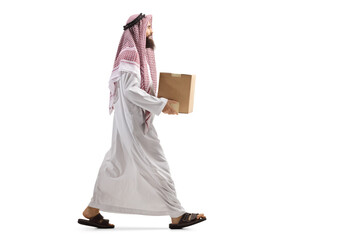 Full length profile shot of a saudi arab man walking with a cardboard box