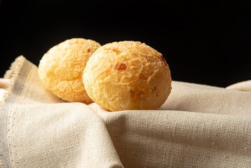 Cheese bread from Brazil, Arrangement with cheese bread on fabric with black background, selective focus.