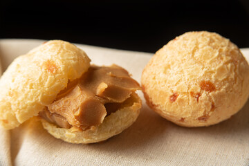 Cheese bread from Brazil, Arrangement with cheese bread and dulce de leche, on fabric with black background, selective focus.