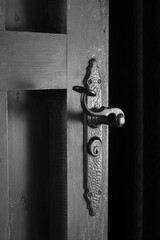 metal decoration on the old and rusty wooden door black and white