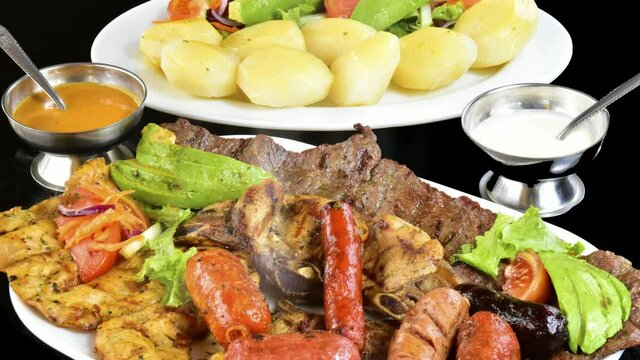 Asado y parrillada caliente con vapor, ensalada fresca, papas cocinadas, salsas y embutidos