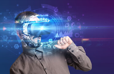 Businessman looking through Virtual Reality glasses with ENERGY inscription, innovative technology concept