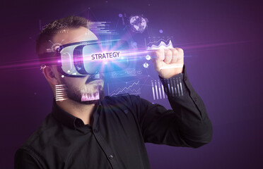 Fototapeta na wymiar Businessman looking through Virtual Reality glasses with STRATEGY inscription, new business concept