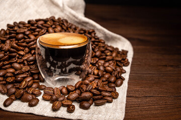Espresso coffee on a dark wooden background. Coffee preparation, close-up, beans.