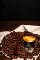 Espresso coffee on a dark wooden background. Coffee preparation, close-up, beans.