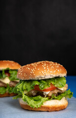 Fresh tasty burger on a blue background. Сheeseburger with chicken cutlet