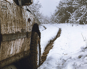 Jeep in mud at snowy forest 