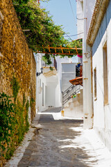 One of the charms of the Greek Cycladic Islands, in the heart of the Aegean Sea are the narrow streets: white houses, small flowered balconies and cobbled stairs