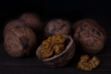 Walnut kernels, and walnuts on a dark background. 