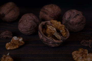 Walnut kernels, and walnuts on a dark background. 