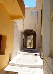 One of the charms of the Greek Cycladic Islands, in the heart of the Aegean Sea are the narrow streets: white houses, small flowered balconies and cobbled stairs
