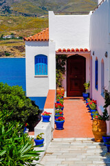 One of the charms of the Greek Cycladic Islands, in the heart of the Aegean Sea are the narrow streets: white houses, small flowered balconies and cobbled stairs
