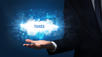 Hand of Businessman holding TAXES inscription, successful business concept